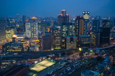 Mavi saat yüksek--dan görüldüğü gibi Osaka Japon şehir içinde yukarı. Şehir ışıkları akşam ışığında parlıyor