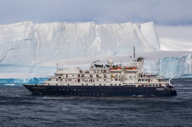 Cruise gemi büyük sekmeli buzdağı Antarktika'daki önünde