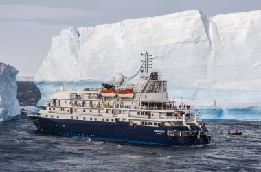 Cruise gemi büyük sekmeli buzdağı Antarktika'daki önünde
