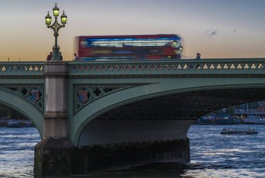 Bir kırmızı Londra veri yolu hızları arasında Westminster Bridge yazlar alacakaranlık.