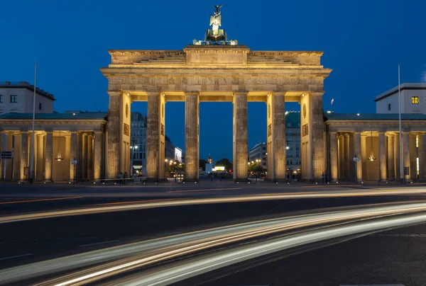 Car light trails streak in front of the Brandenburg gate in the evening. Berlin