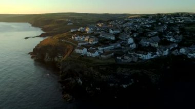 Dışarı çerçeve güneş yükselir olarak dron geri bağlantı noktası Isaac Cornwall clifftop evler çeker. 
