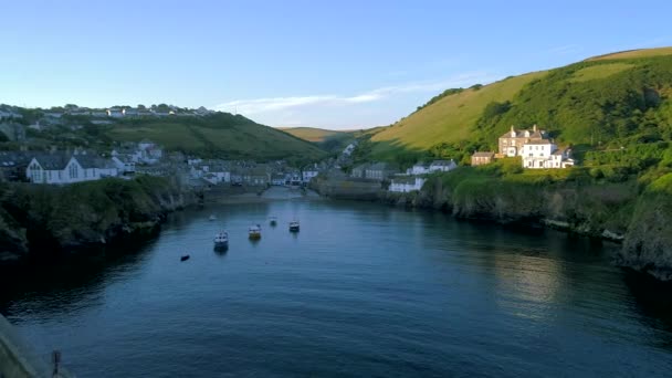Drone flies in through the harbor of Port Isaac towards the village as the sun rises — Stock Footage Drone Flies Harbor Port Isaac Village Sun Rises Royalty Free Stock Video