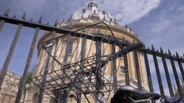 Kamera güneşli bir yaz sabahı Oxford Radcliffe kamera ortaya çıkarmak için kilitli bisiklet geçmiş yükselir 