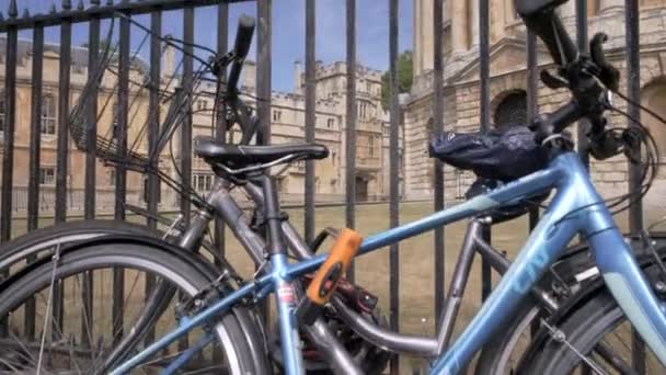 カメラは 晴れた夏の朝にラドクリフ広場とオックスフォードのカメラを明らかにするロックされた自転車過去上昇します — ストック動画