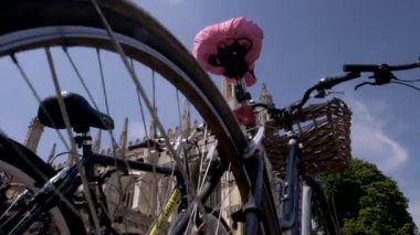 Fotoğraf makinesi, Cambridge 'deki Kings College Şapeli ortaya çıkarmak için döngülerin arkasındaki satırlardan yükselir. Çekim yoğun bir öğleden sonra yaz 2018