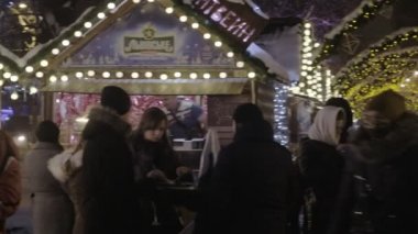 Karlı bir kış akşamı Lviv Noel pazarının ana kısmına gıda tezgahları Pan. 