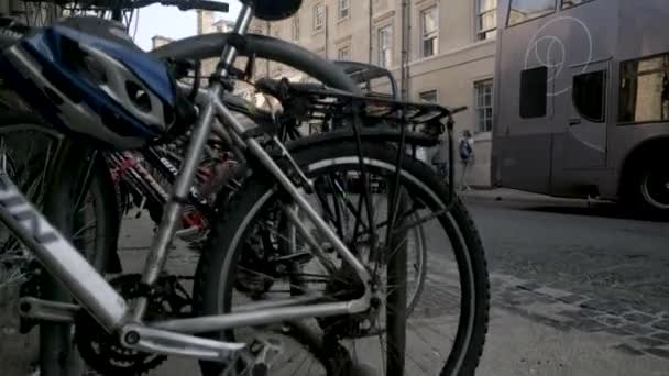 从停放的自行车后面升起 露出自行车和公共汽车 — 图库视频影像