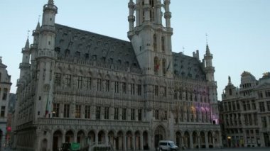 Grand Place'deki Brüksel Belediye Binası'nın ön cephesini eğin. Meydanda birkaç kişi ile şafakta çekilen