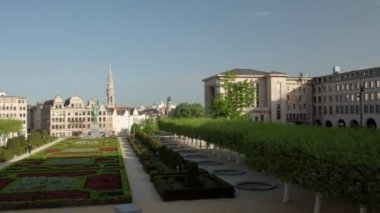 Mont des Arts karşısında Belçika Kütüphanesi'ne pan. Kral Albert'In heykeli ve belediye binası nın kulesi arka planda.