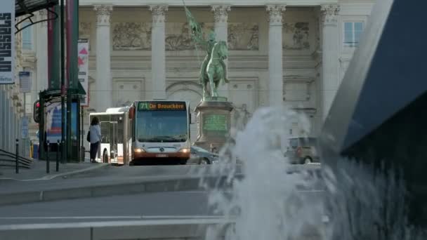 布鲁塞尔 比利时 2019年4月24日 一辆公共汽车抵达布鲁塞尔蒙塔尼亚河车站的静态长镜头 布耶隆的戈弗雷雕像在后面 镜头被喷泉框住 — 图库视频影像