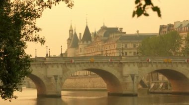 Şafak alacakaranlıkta Paris'te Pont Neuf'u vurdu. Bahar ağaçları ile çerçeveli