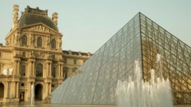 Paris/Fransa - 30 Nisan 2019: Louvre Piramidi ve Paris'teki çeşmeyi yavaşça aşağı yat. Ana Galeri arkasında