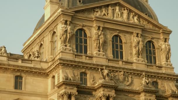 中间镜头向下倾斜的卢浮宫德龙亭的外墙到喷泉之一 清晨在金色的灯光下拍摄 — 图库视频影像