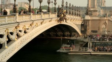 Paris/Fransa - 30 Nisan 2019: Paris'te akşam saatlerinde Alexandre III köprüsünün altından geçen tur teknesi tam yolcu