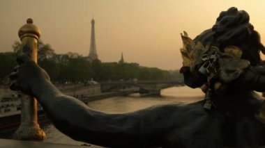 Alexandre III köprüsü ve arka planda Eyfel Kulesi kilitleri ile Perisi Heykeli, Paris'te gün batımı sırasında alınan, Fransa