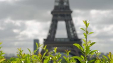 Trocadero Paris'te çitin üstündekamera kaydırıyor. Eyfel Kulesi arka planda odak dışında. Kısmen güneşli bir bahar gününde alınan