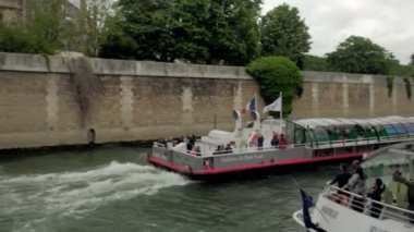 Kamera Notre Dame katedrali yanında bir River Seine tur tekne izler 