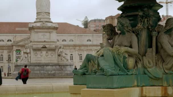 リスボン ポルトガルで通り過ぎる人々としてロッシオ広場の噴水の彫刻のクリップを閉じます — ストック動画