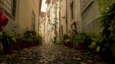 lizbon Alfama ilçesinde dar arnavut kaldırımlı backstreet sağdan sola ow açısı kaydırıcı atış, Portekiz