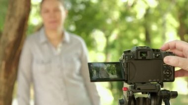 Bir tripod monte kamera ile bir portre çeken fotoğrafçının yakın çekim. Konu arka planda defokus