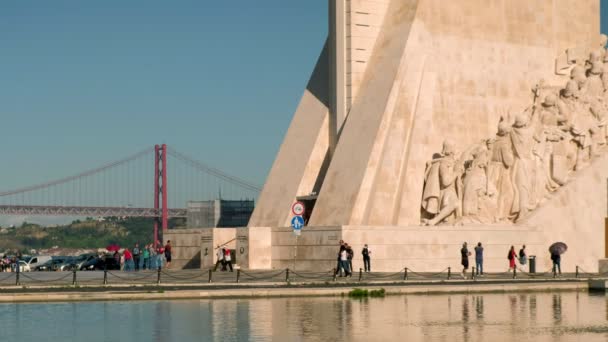 포르투갈 리스본의 지역에서 유물들을 기리기 기념물 근처를 관광객들의 브리지 배경에 — 비디오