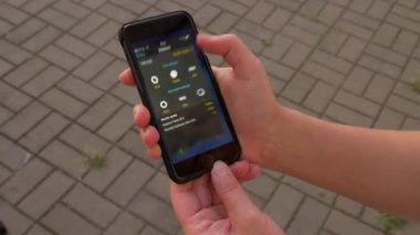 Fotoğrafçı akıllı telefonda bir pozlama hesap makinesi uygulaması açar 