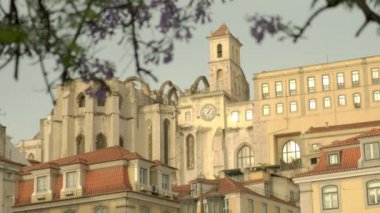 Lizbon 'daki Carmo Manastırı' nın uzun bir klibi. Rossio Meydanı 'ndaki Jacaranda çiçeği çerçeveli. Sabah altın saatinde çekilen