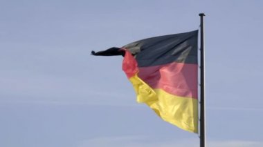 Berlin 'deki Reichstag Binası üzerinde dalgalanan büyük Alman bayrağının ultra yavaş çekim klibi