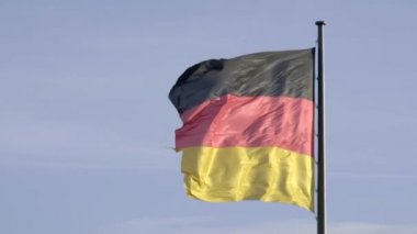 Berlin 'deki Reichstag Binası üzerinde dalgalanan büyük Alman bayrağının ultra yavaş çekim klibi