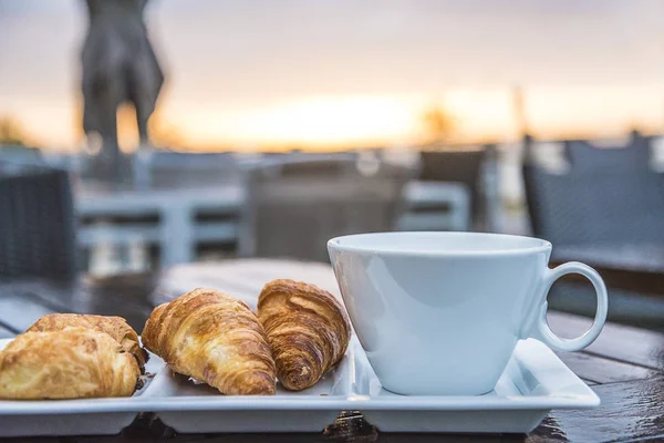 Café da manhã com croissants no terraço da praia do mar e nascer do sol — Fotografia de Stock