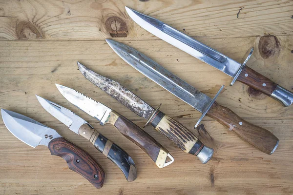 Various hunting knives on the rustic wooden background — Stock Photo, Image