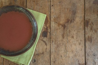 Empty rustic plate on the green napkin on the old wooden background