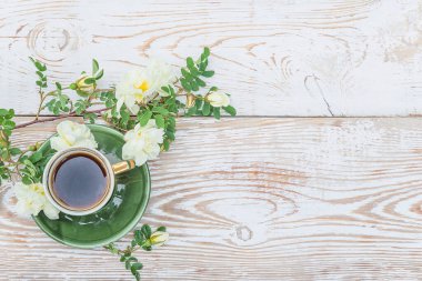 Eski usul kahve molası. Eski bir fincan kahve, yaban gülü dalı