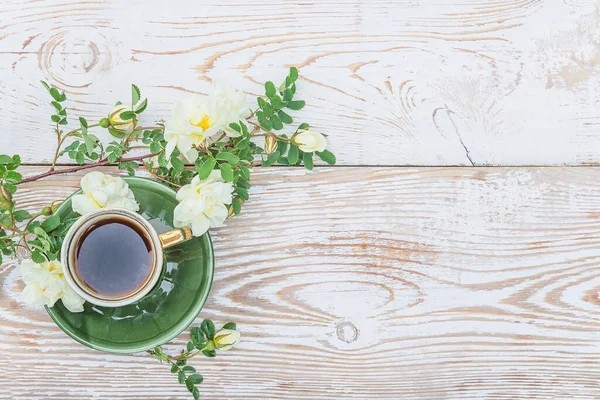 Eski usul kahve molası. Eski bir fincan kahve, yaban gülü dalı