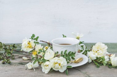 Geçmişe dönük romantik tebrik kartı. Beyaz kahve ve beyaz yaban gülleri.