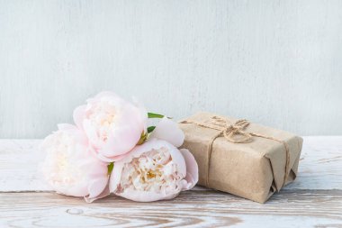 Romantik tebrik kartı. El yapımı hediye kutusu ve beyaz şakayıklar. 