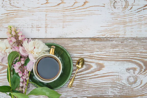 Şakayıklı romantik tebrik kartı ve beyaz boya ahşap arka planda bir fincan kahve.