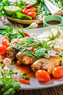 Domates sos, sebze ve otlar masaya bir tabak içinde uskumru. Yum uskumru, Tayland mutfağı stili.