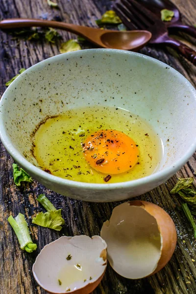Raw eggs in a bowl on a wooden table. Eggs can be used to cook a lot.