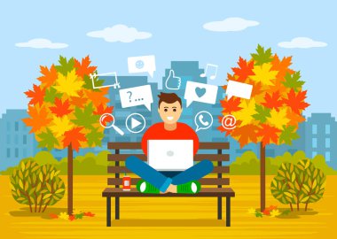 genç bir adam bilgi arayışı içinde sosyal ağlarda bir sonbahar parkında bir dizüstü bilgisayar ile bir bankta oturuyor. Modern bir kişi kavramı, uzaktan çalışma, bir serbest online çalışma.
