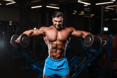 Yakışıklı genç uygun kas beyaz adam kilo kas, pozlar, pompalama spor modeli görünüm egzersiz eğitim su fitness ve vücut geliştirme spor beslenme kavramı içecekler