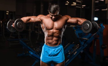 Yakışıklı genç uygun kas beyaz adam kilo kas, pozlar, pompalama spor modeli görünüm egzersiz eğitim su fitness ve vücut geliştirme spor beslenme kavramı içecekler