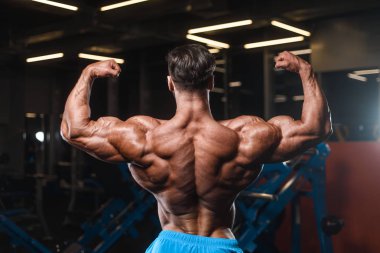 Yakışıklı genç uygun kas beyaz adam kilo kas, pozlar, pompalama spor modeli görünüm egzersiz eğitim su fitness ve vücut geliştirme spor beslenme kavramı içecekler