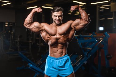 Yakışıklı genç uygun kas beyaz adam kilo kas, pozlar, pompalama spor modeli görünüm egzersiz eğitim su fitness ve vücut geliştirme spor beslenme kavramı içecekler