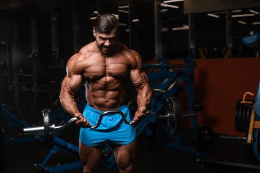 Yakışıklı genç uygun kas beyaz adam kilo kas, pozlar, pompalama spor modeli görünüm egzersiz eğitim su fitness ve vücut geliştirme spor beslenme kavramı içecekler
