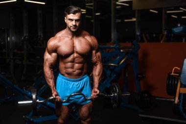 Yakışıklı genç uygun kas beyaz adam kilo kas, pozlar, pompalama spor modeli görünüm egzersiz eğitim su fitness ve vücut geliştirme spor beslenme kavramı içecekler