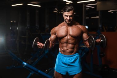 Yakışıklı genç uygun kas beyaz adam kilo kas, pozlar, pompalama spor modeli görünüm egzersiz eğitim su fitness ve vücut geliştirme spor beslenme kavramı içecekler