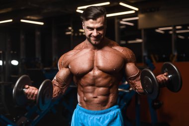 Yakışıklı genç uygun kas beyaz adam kilo kas, pozlar, pompalama spor modeli görünüm egzersiz eğitim su fitness ve vücut geliştirme spor beslenme kavramı içecekler