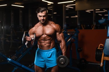 Yakışıklı genç uygun kas beyaz adam kilo kas, pozlar, pompalama spor modeli görünüm egzersiz eğitim su fitness ve vücut geliştirme spor beslenme kavramı içecekler